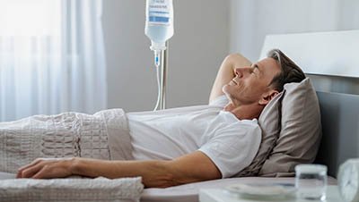 Пациент лежит под капельницей на дому